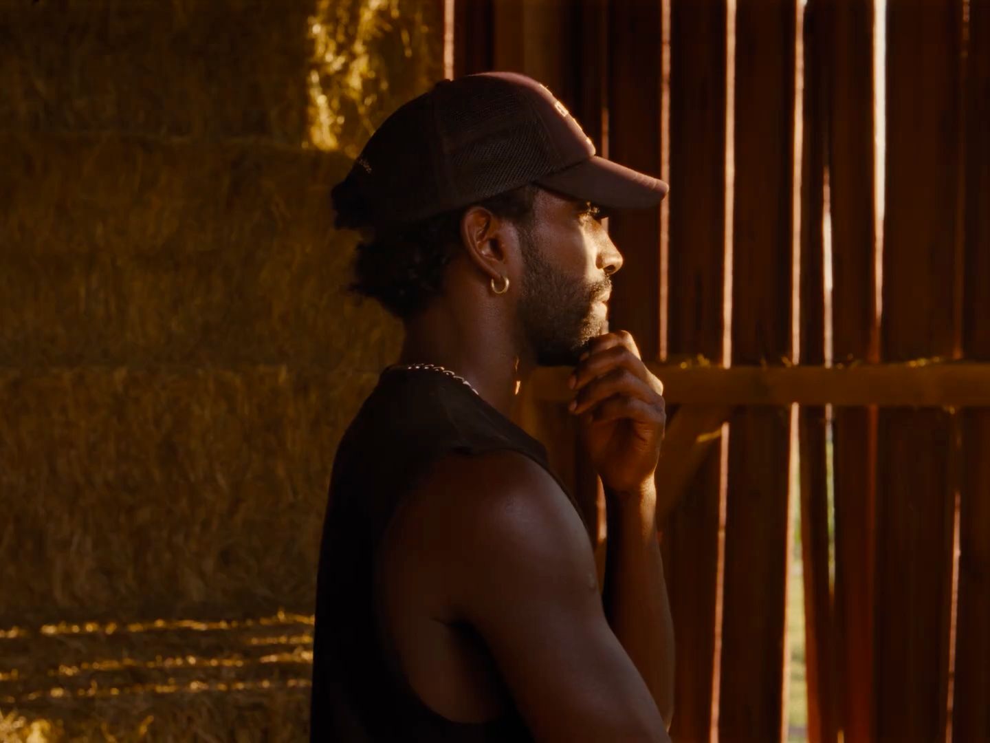 a man in a hat is standing in front of a window