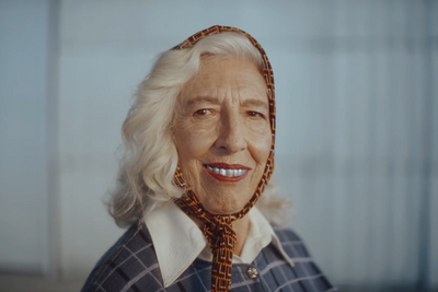 an older woman with white hair wearing a neck tie