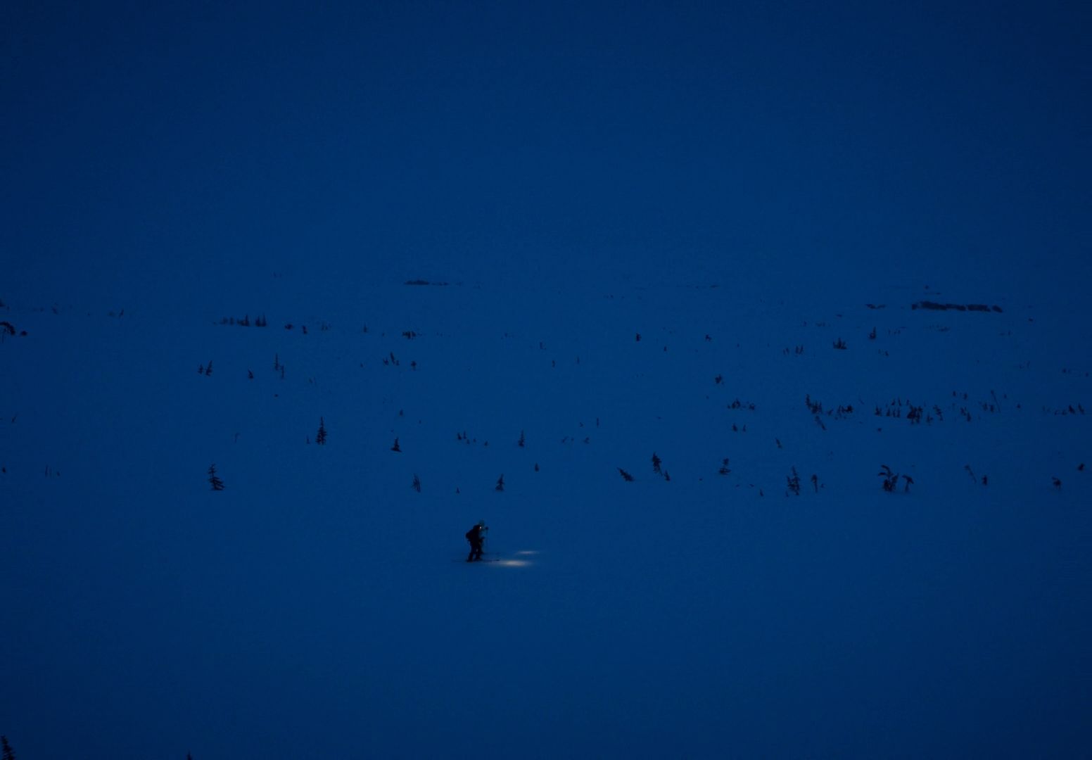 a person standing in the snow at night