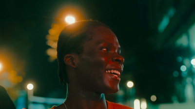 a woman smiling at the camera at night