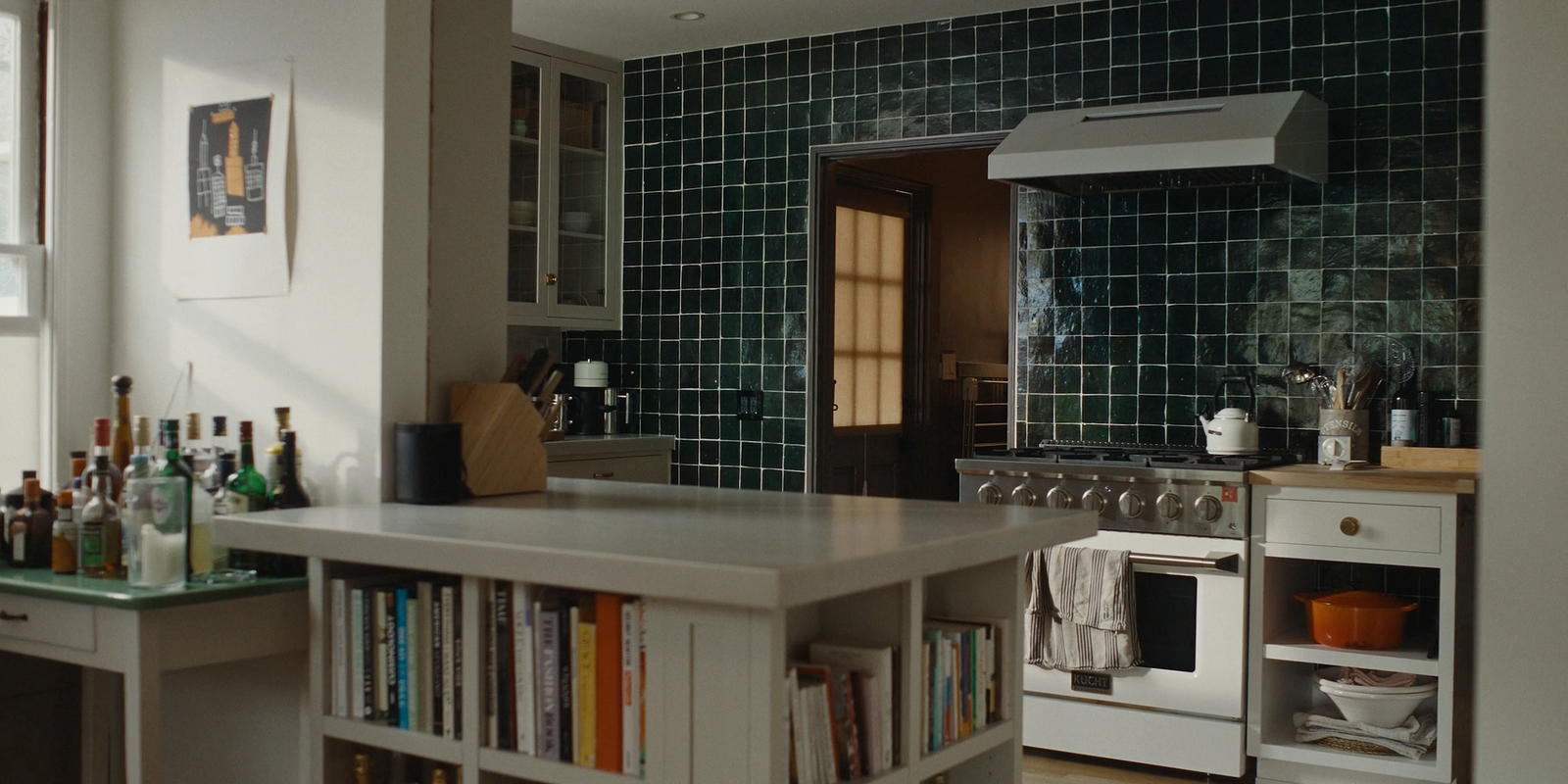 a kitchen with a stove, sink, and bookcase