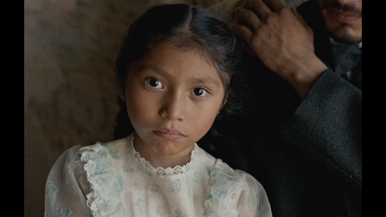 a little girl is sitting next to a man