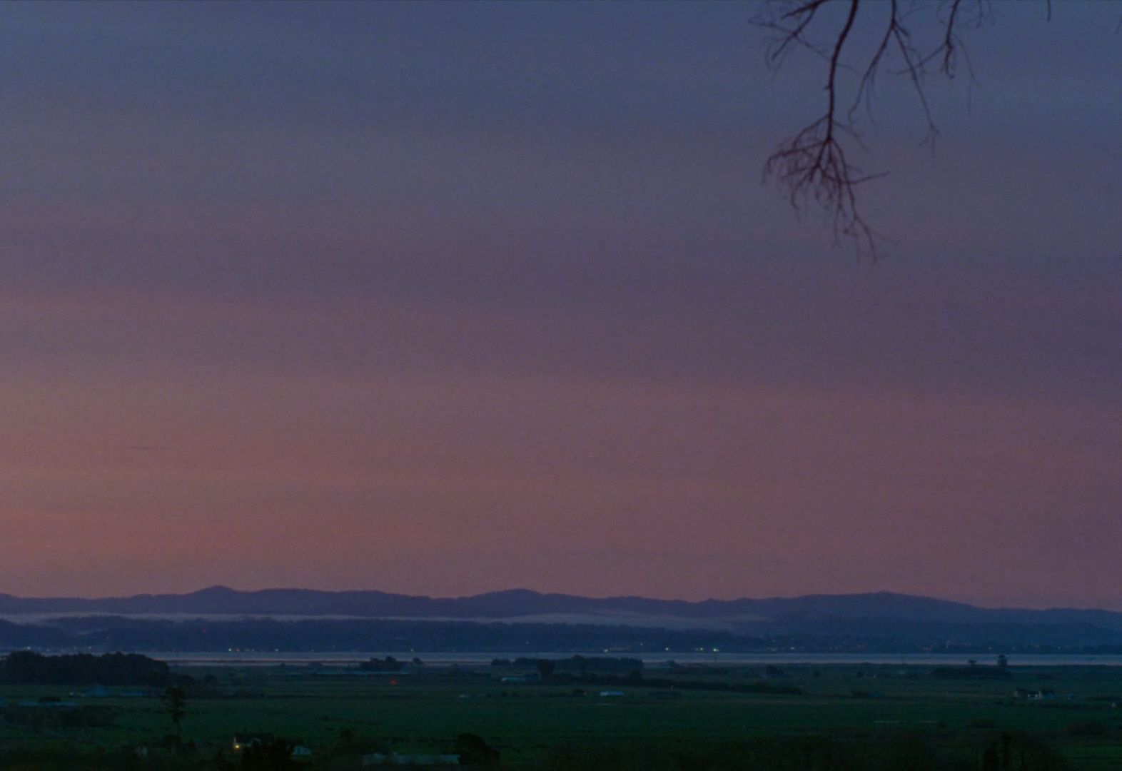 a view of a field with mountains in the distance