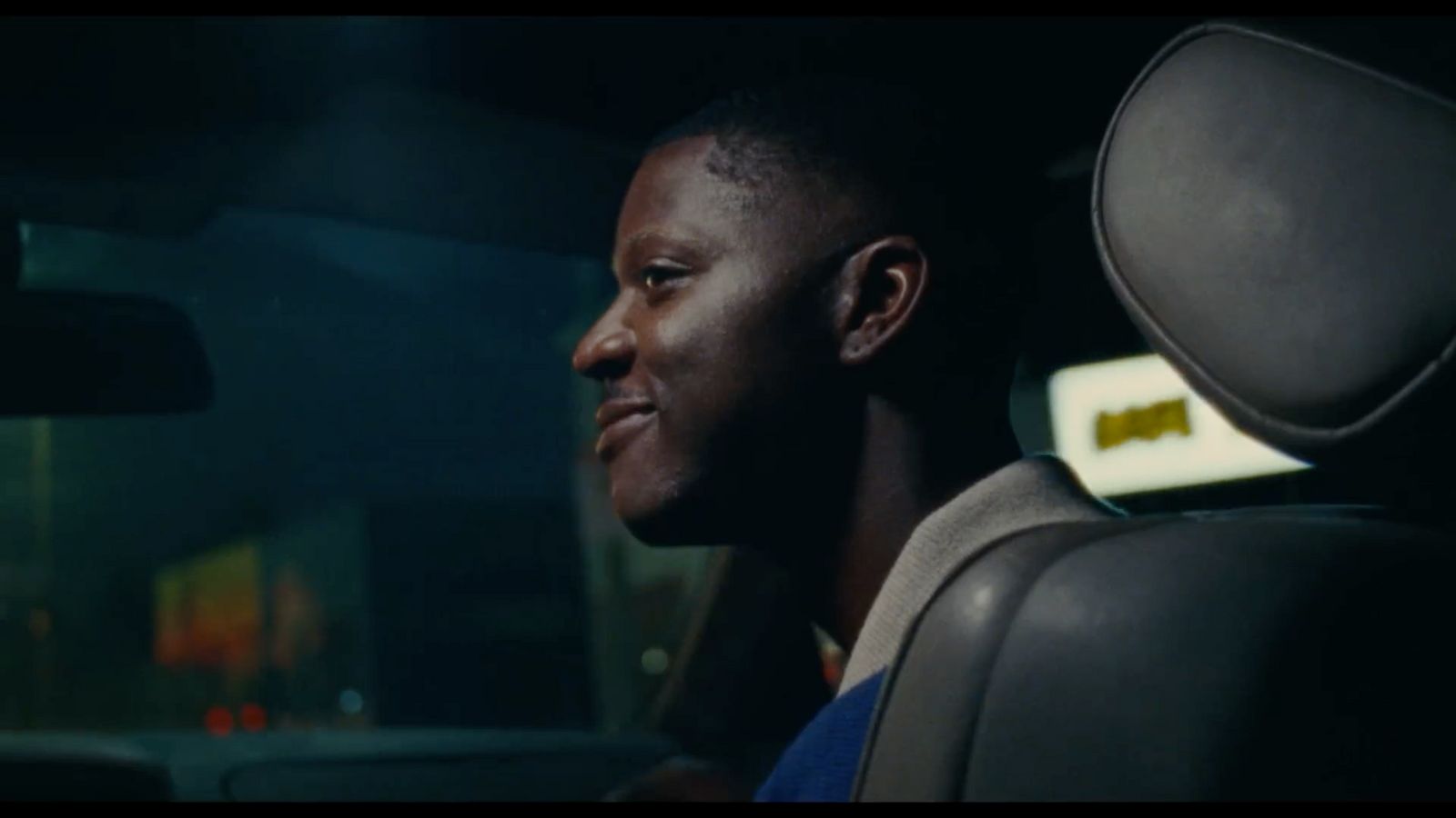 a man sitting in a car looking out the window