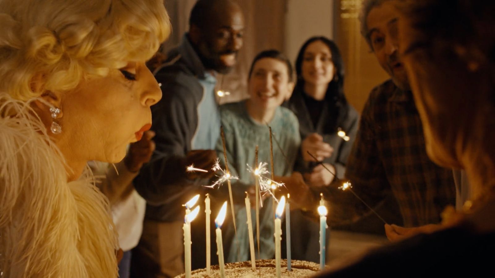 a woman blowing out candles on a cake