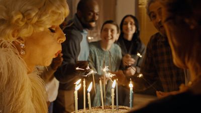 a woman blowing out candles on a cake