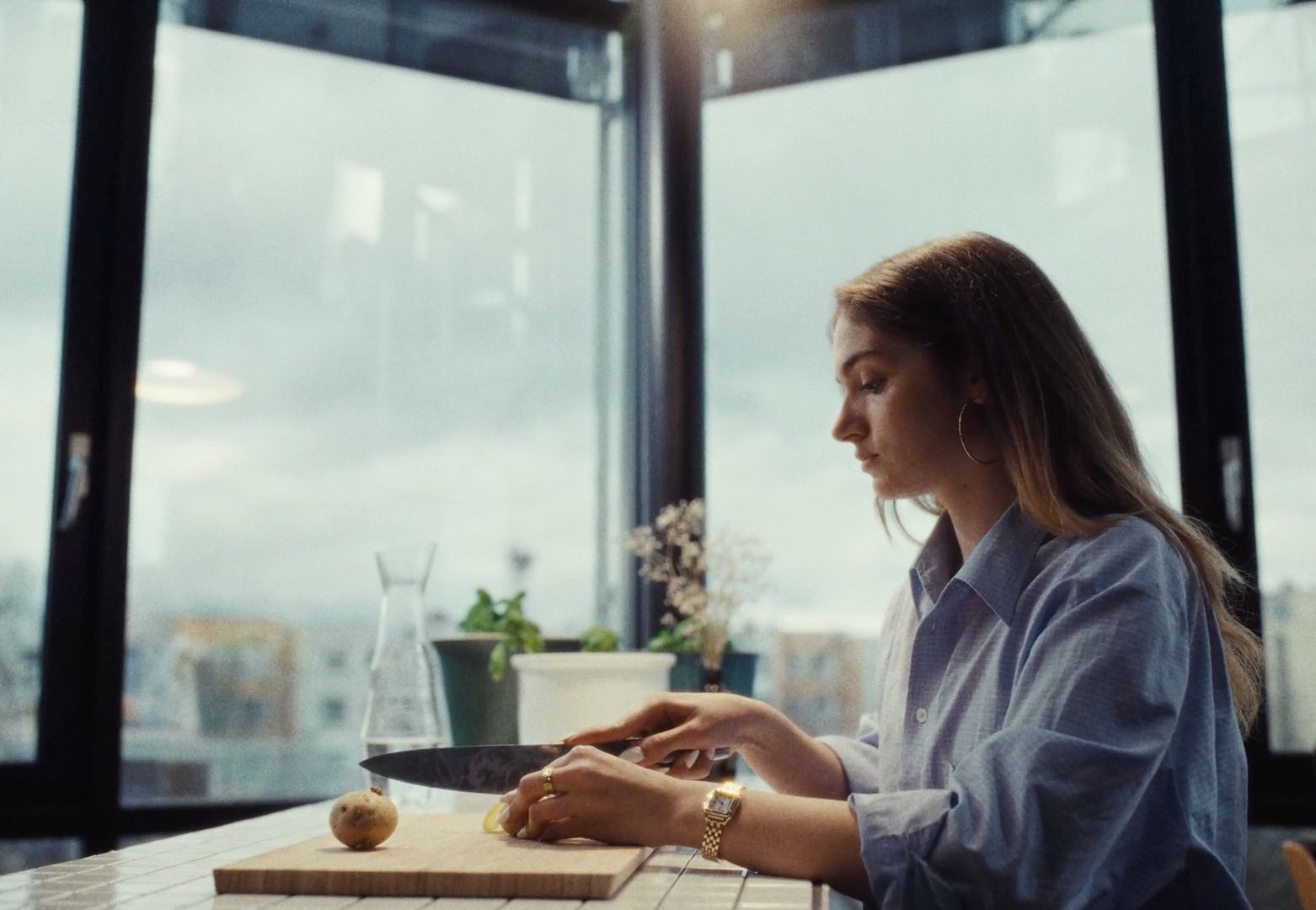 a woman sitting at a table with a knife in her hand