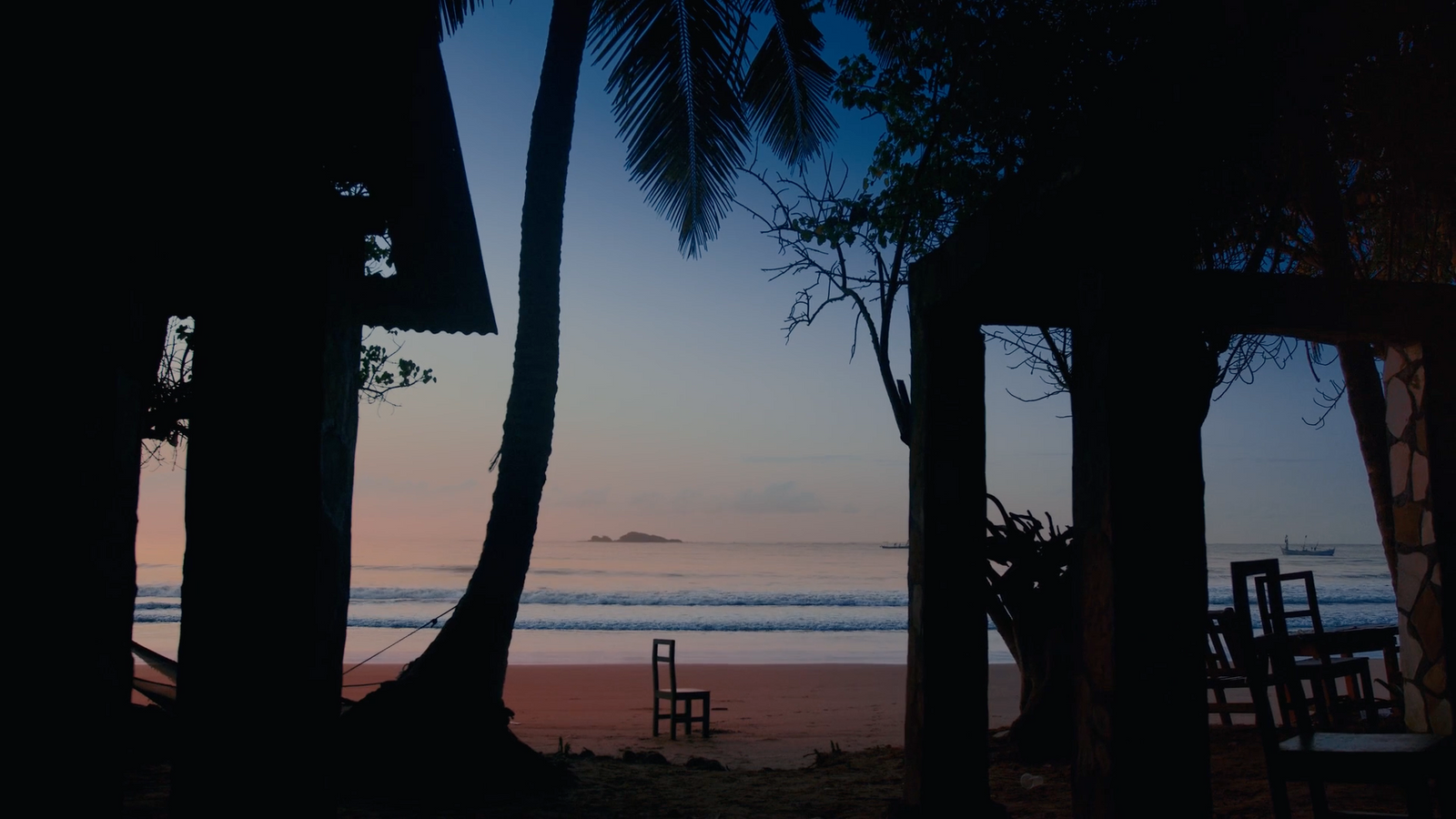 a view of the ocean from a beach at dusk