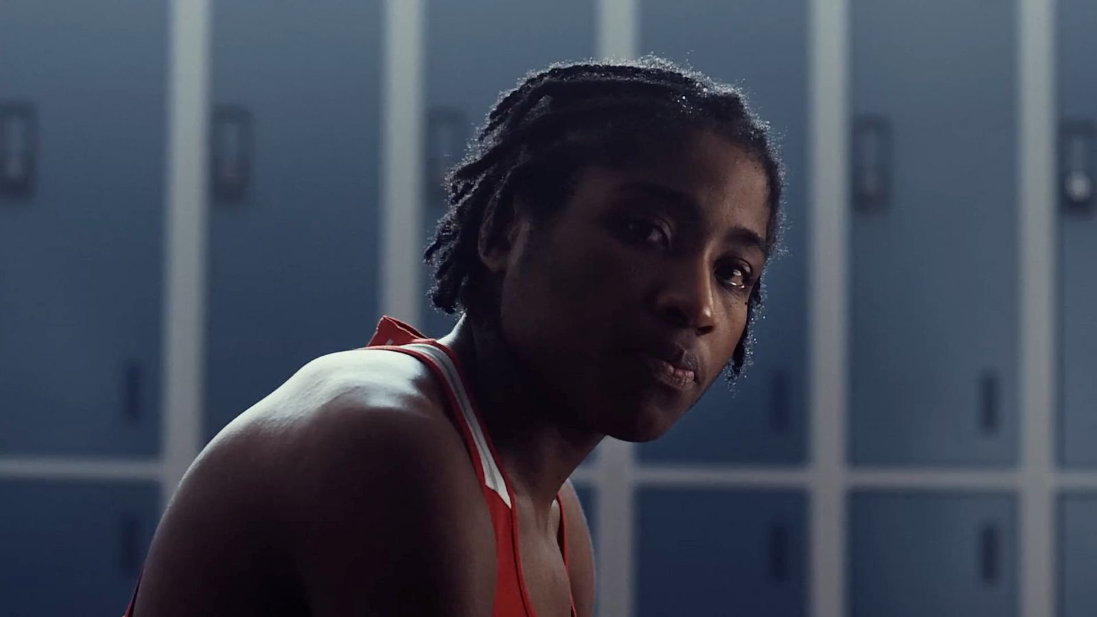 a woman with dreadlocks standing in front of lockers