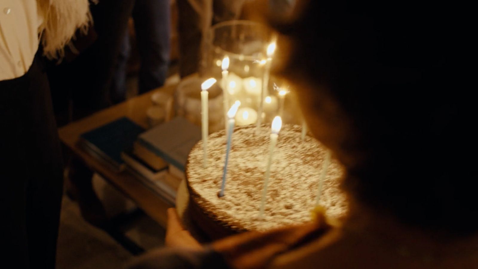 a person holding a cake with candles on it