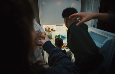 a group of people standing in front of an open refrigerator