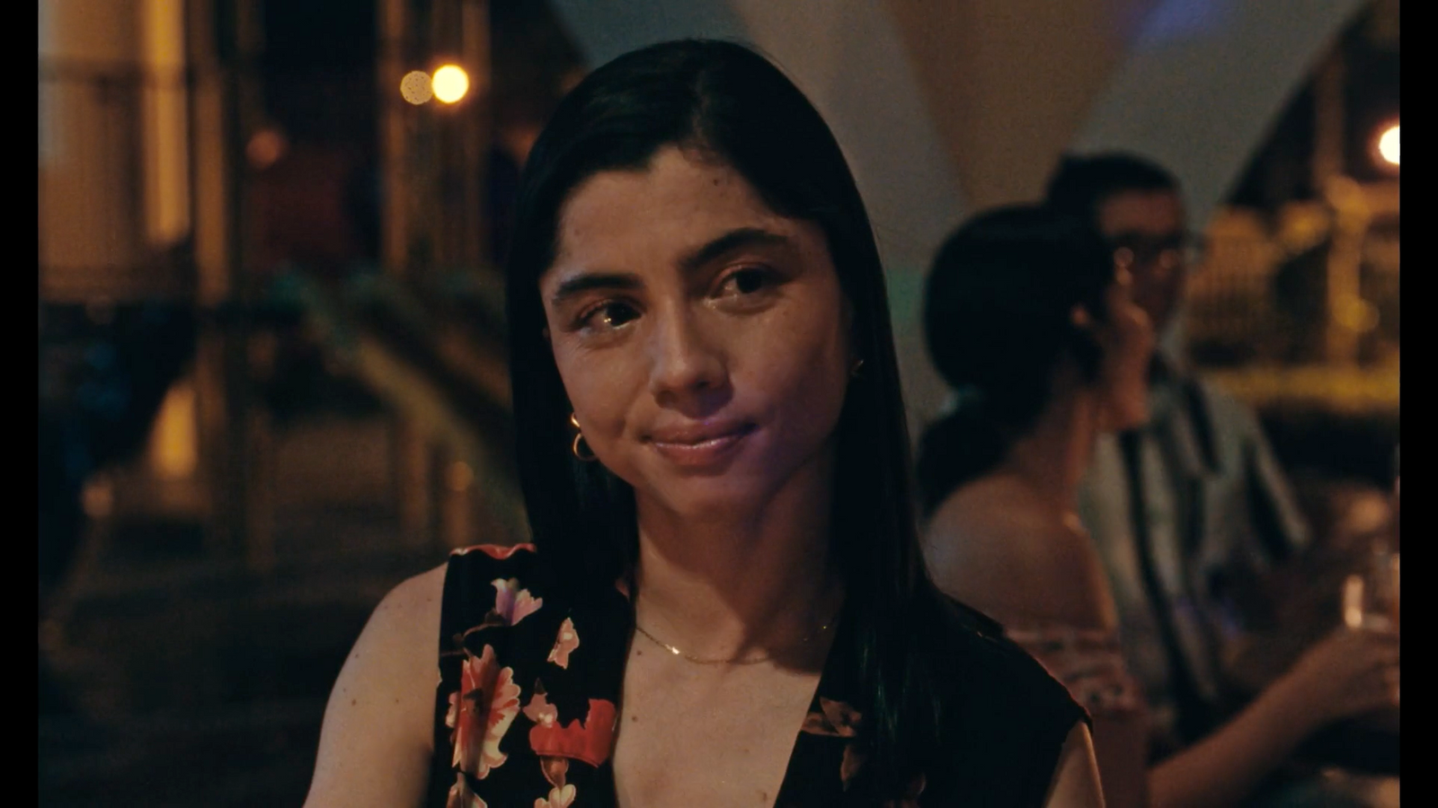 a woman in a floral top sitting at a table