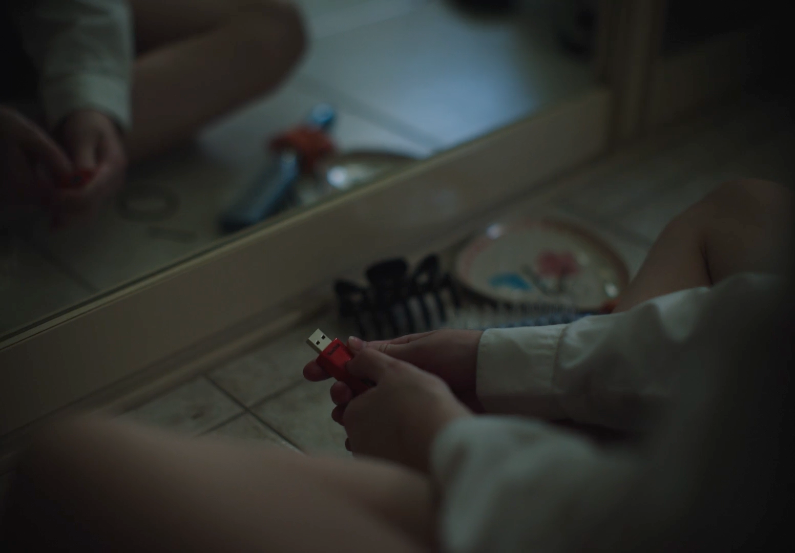 a person sitting on the floor in front of a mirror