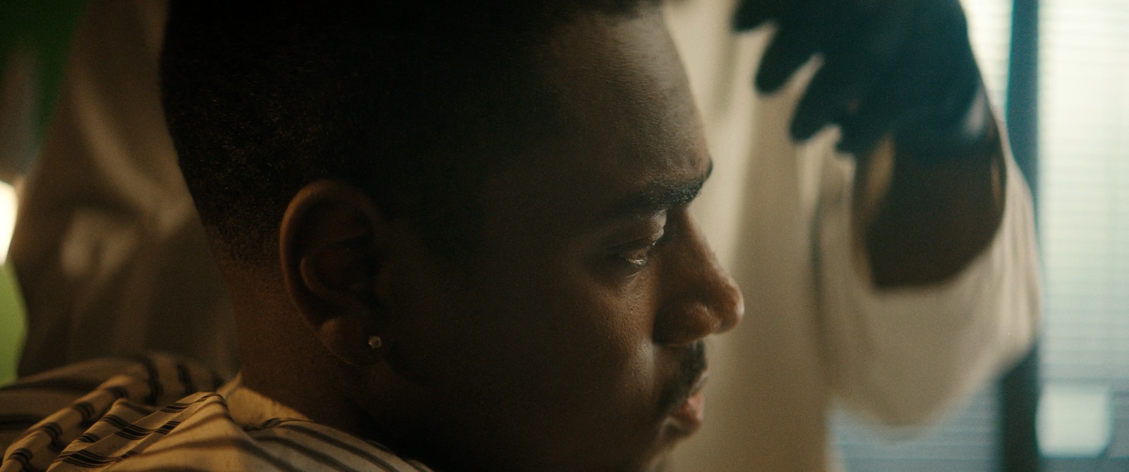 a close up of a person getting his hair cut