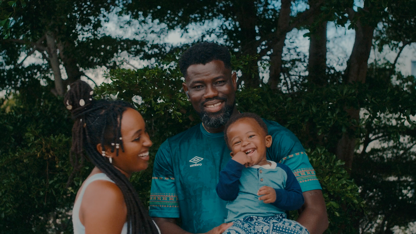 a man and woman holding a baby in their arms