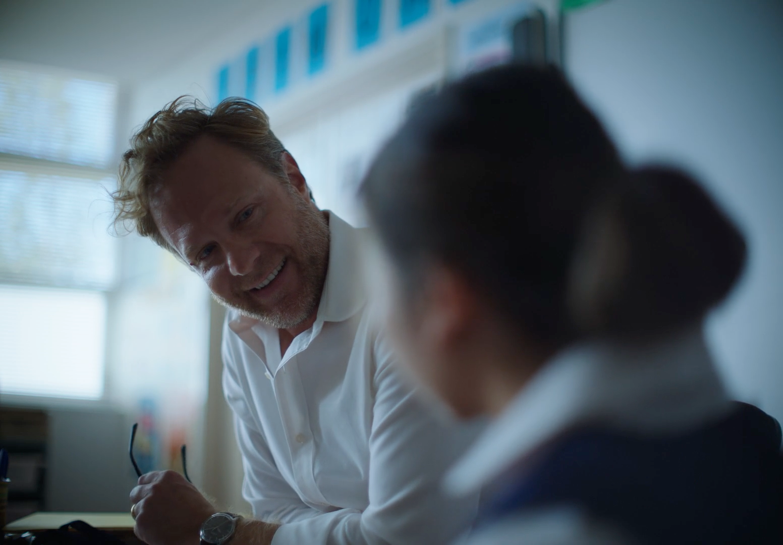 a man smiles as he talks to a woman