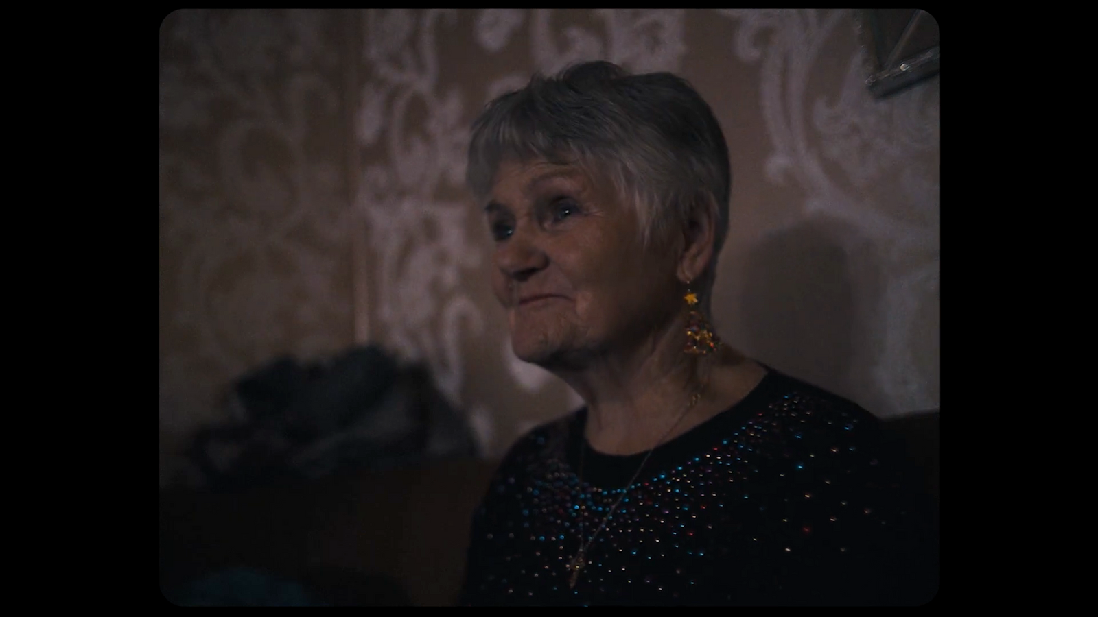 an older woman with grey hair and earrings