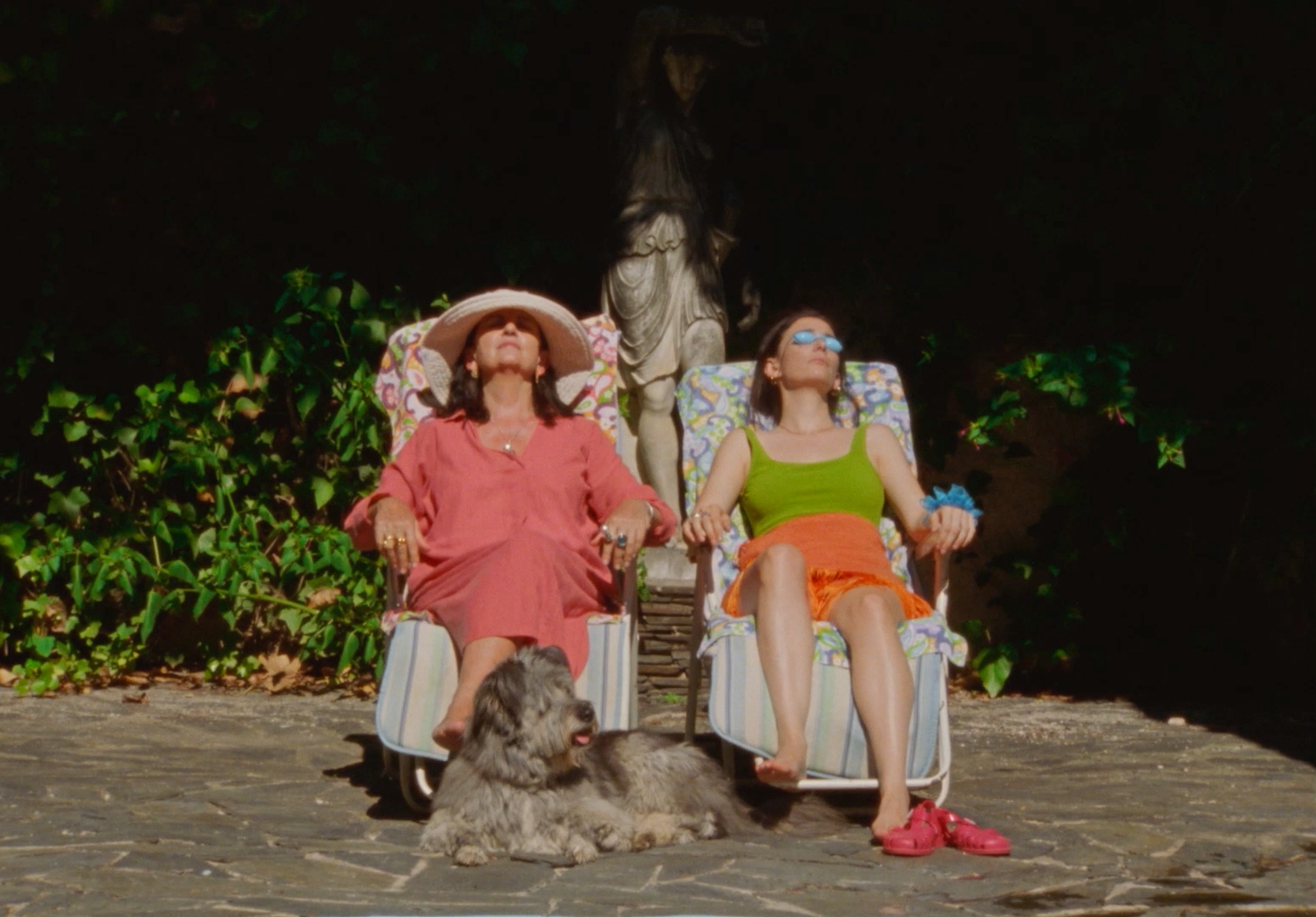 two women sitting in lawn chairs with a dog