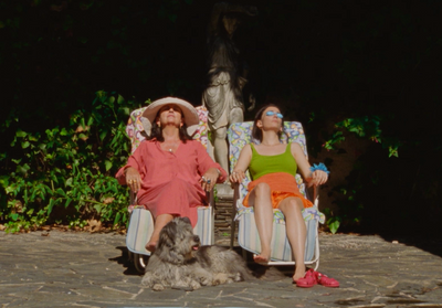 two women sitting in lawn chairs with a dog