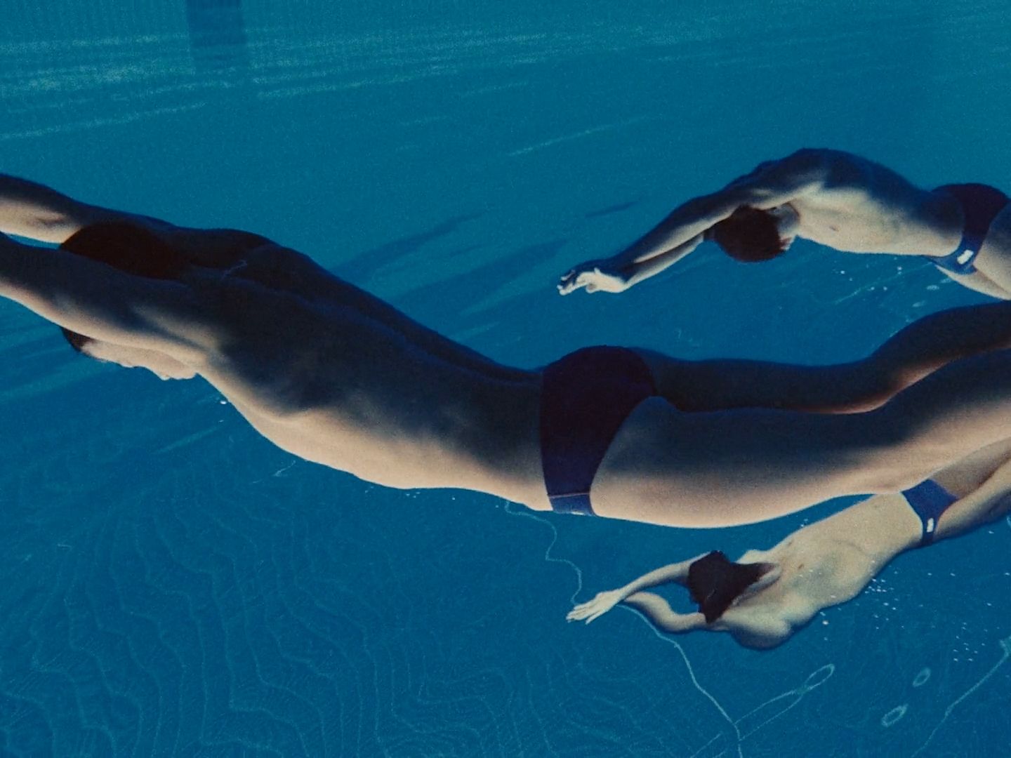 a man is swimming in a pool with no shirt on