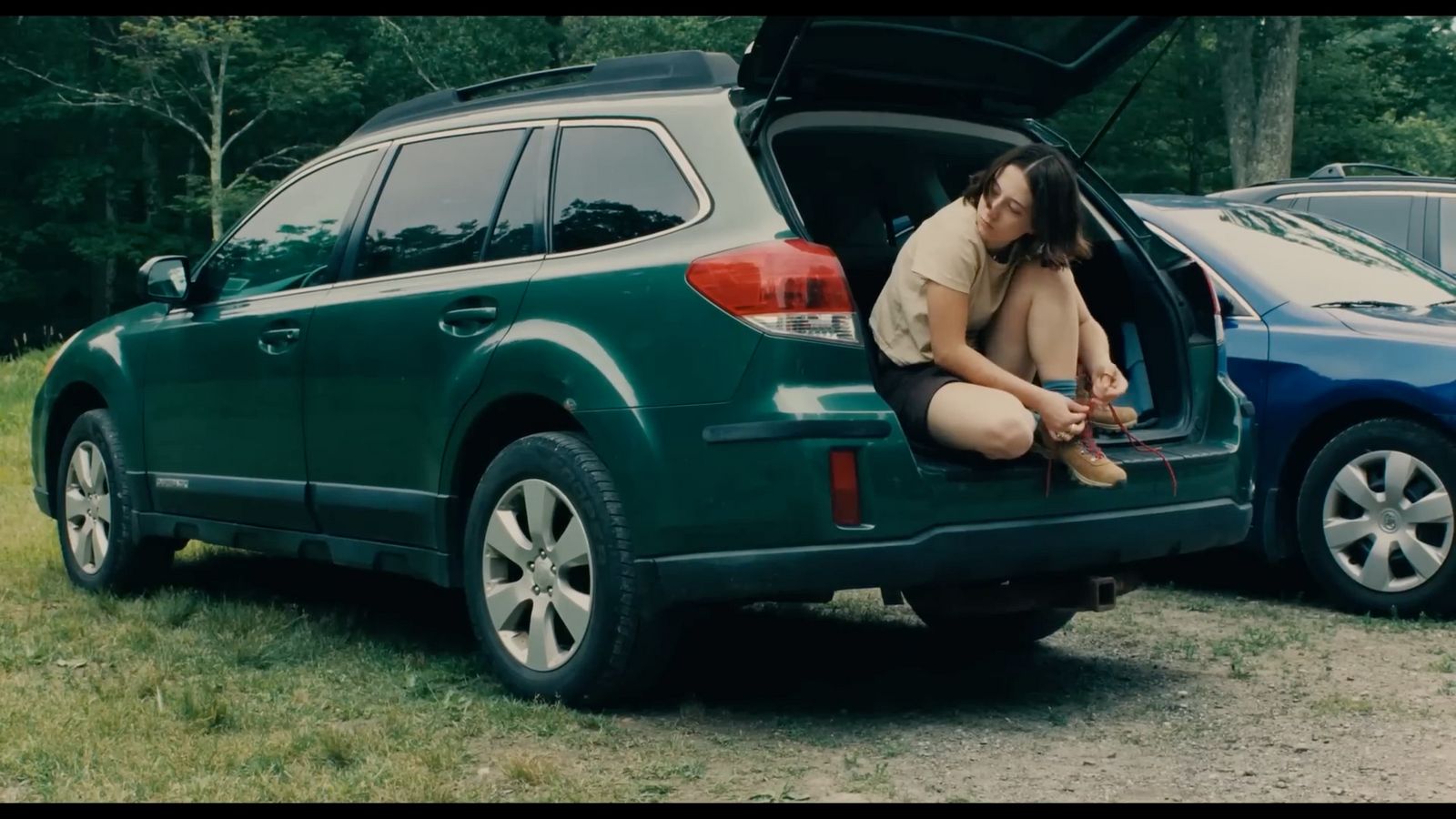 a woman sitting in the back of a green car