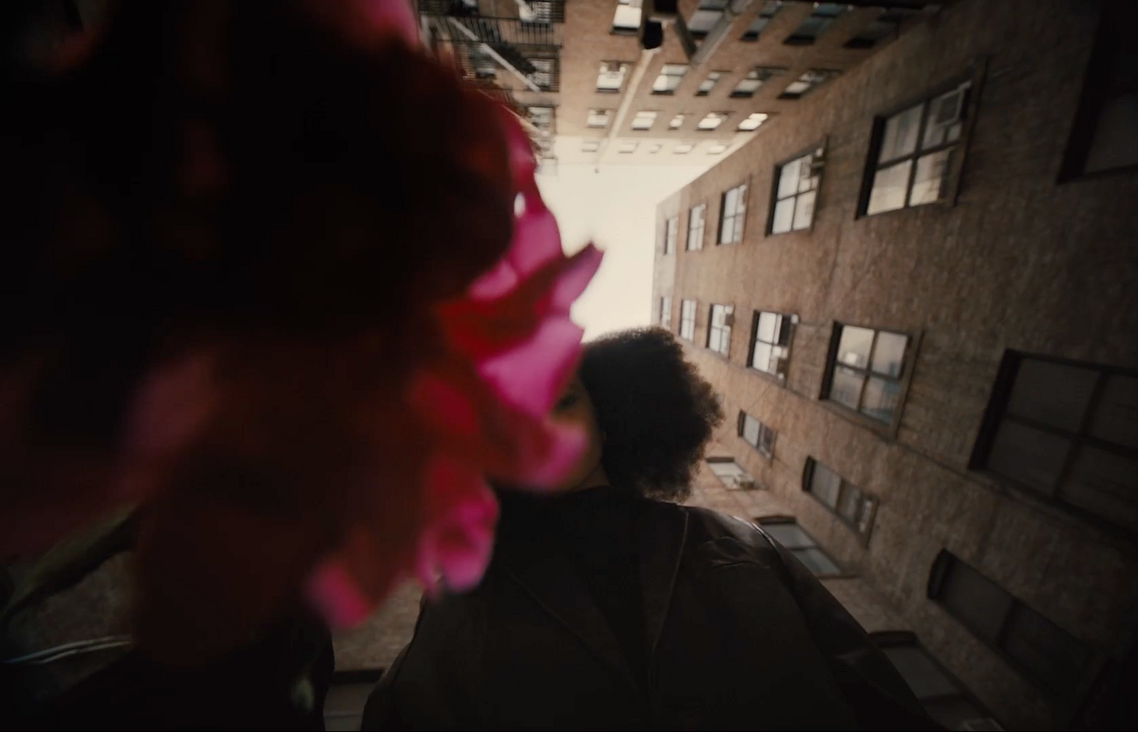 a person walking down a street next to tall buildings