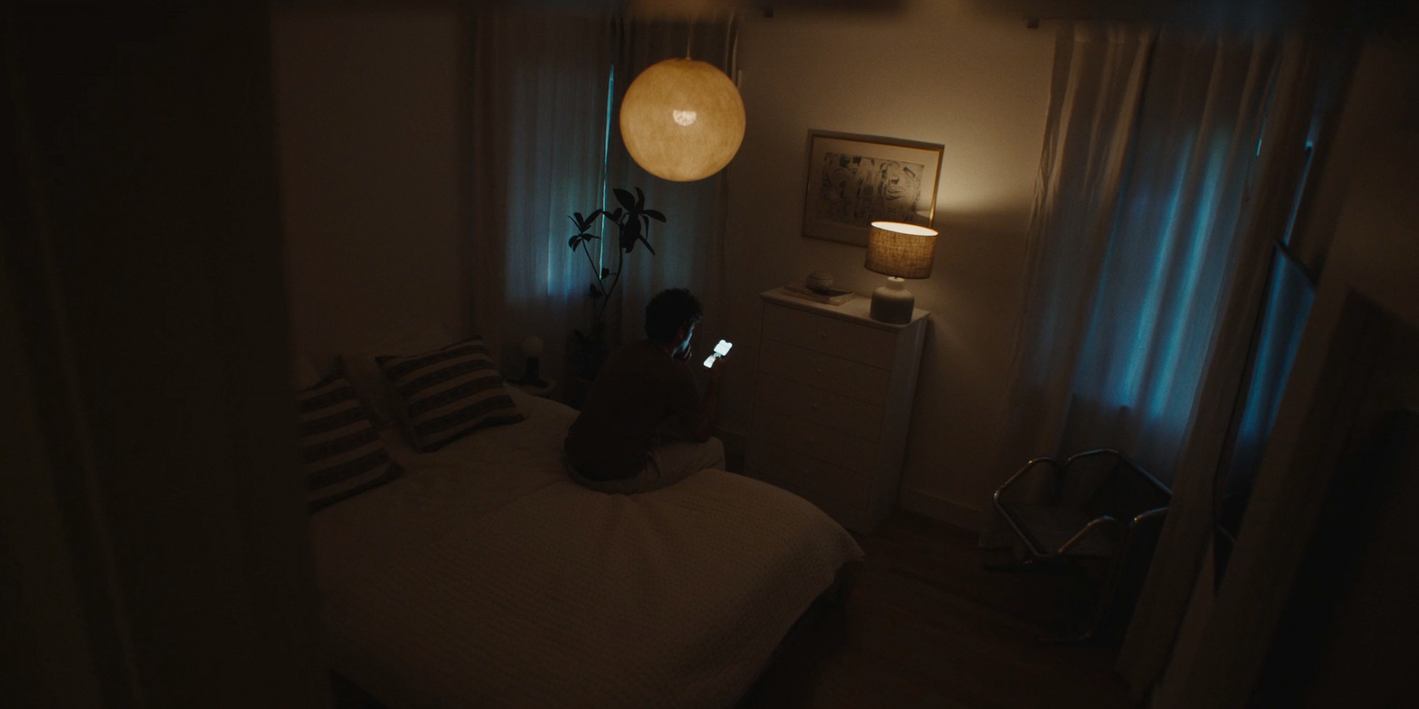 a person sitting on a bed in a dark room