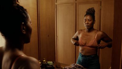 a woman standing in front of a mirror brushing her teeth