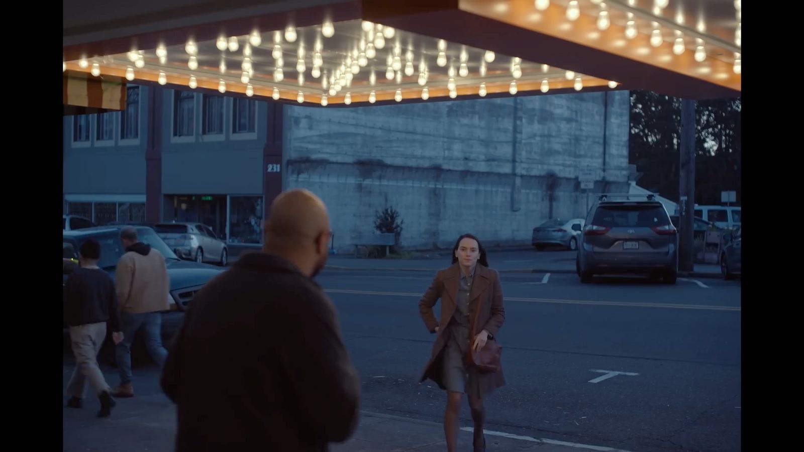 a woman walking down a street next to a man