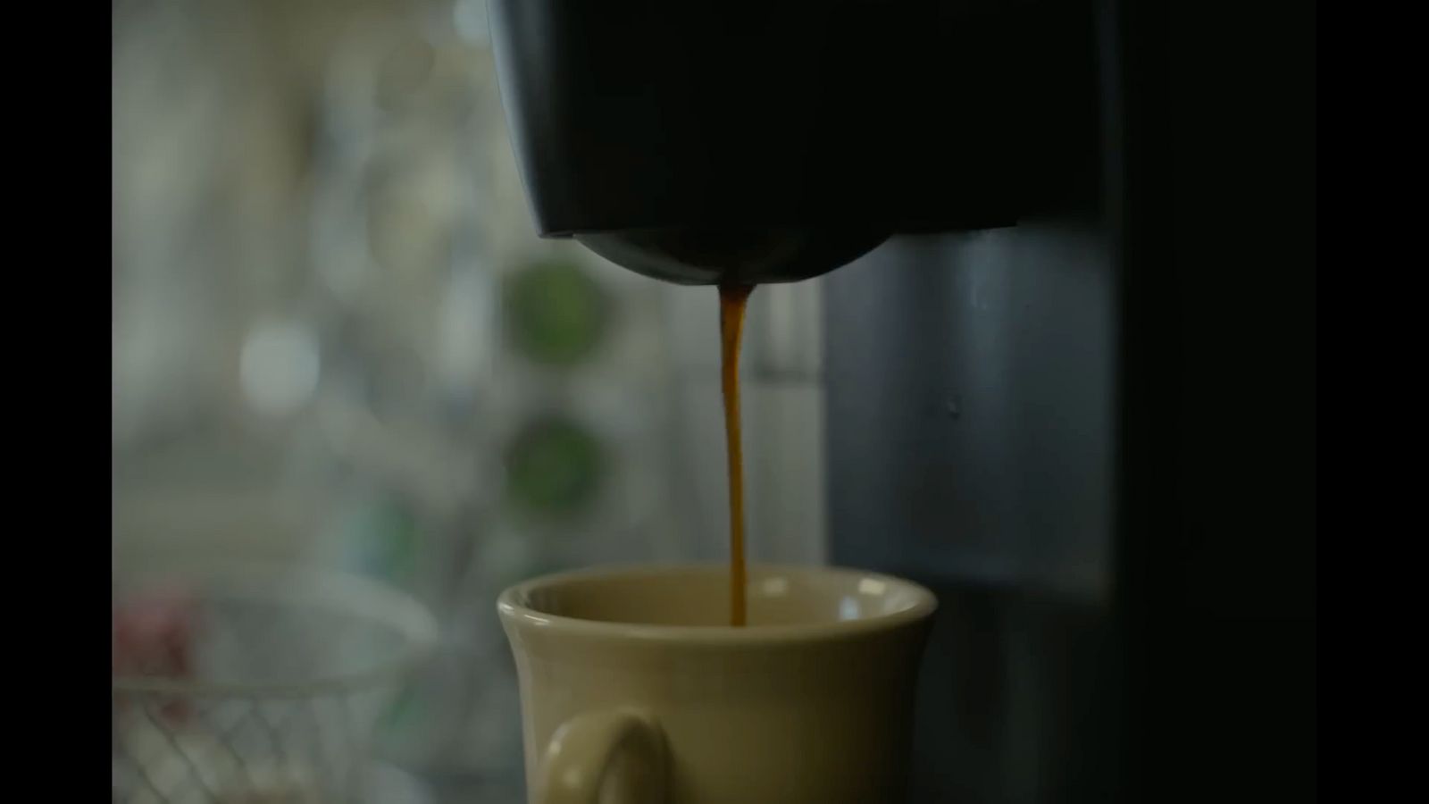 a coffee maker pouring coffee into a cup