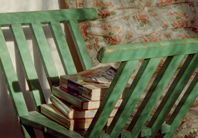 a wooden bench with a stack of books on top of it