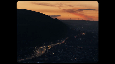 a view of a city from a hill at sunset