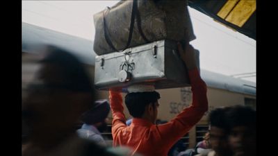 a man carrying a suitcase on his head