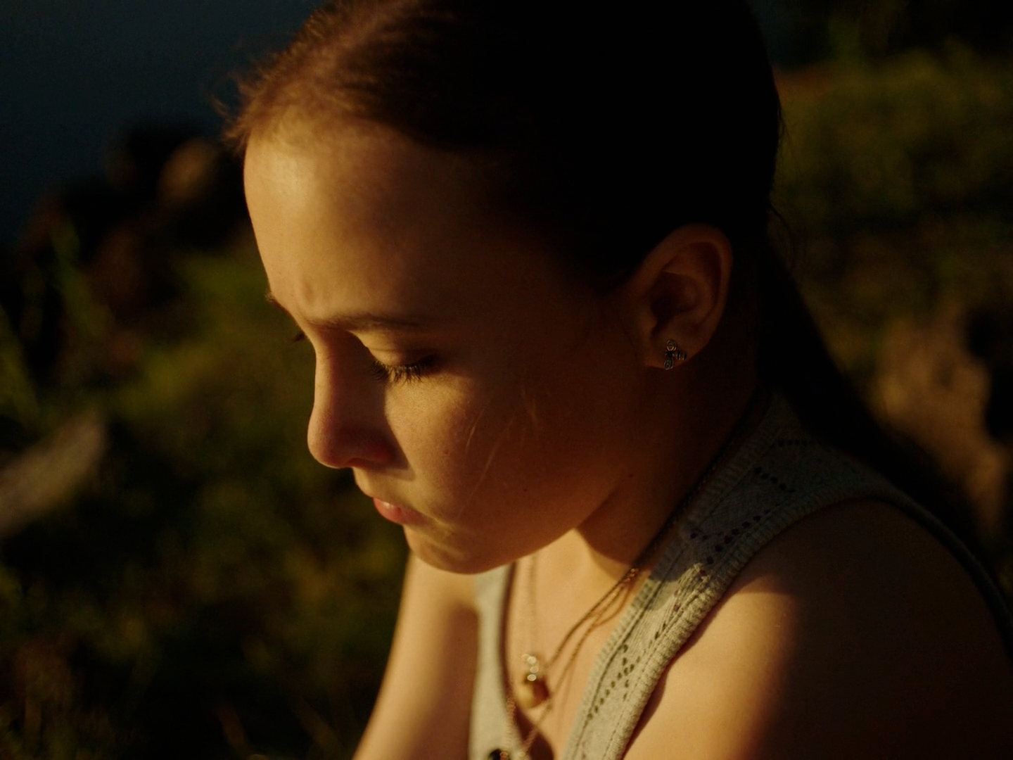 a young girl is looking down at her cell phone