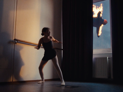 a woman in a black leotard is holding a pole