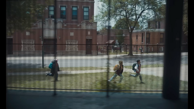 a group of people walking across a grass covered field