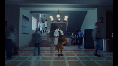 a woman standing in a hallway with a bunch of people