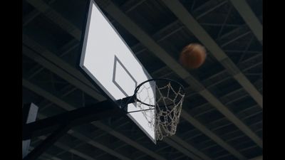 a basketball going through the net of a basketball court