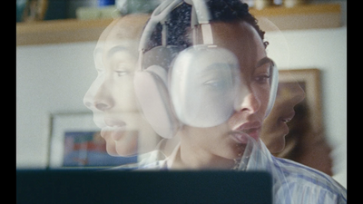 a couple of people with headphones in front of a laptop