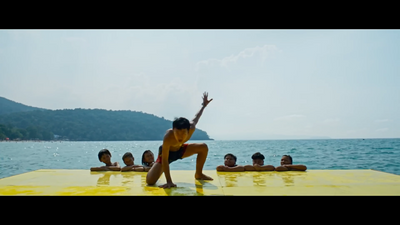 a man doing a yoga pose in front of a group of people