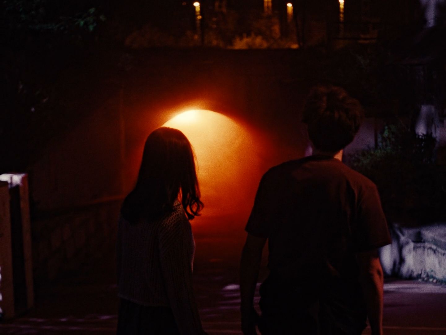 a man and a woman standing in front of a tunnel