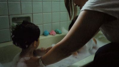 a woman is washing a child in a bathtub