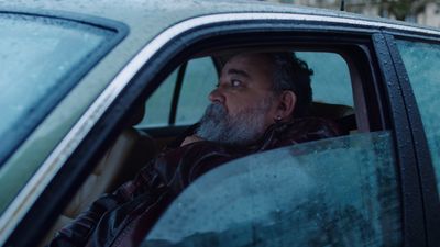 a man sitting in a car looking out the window