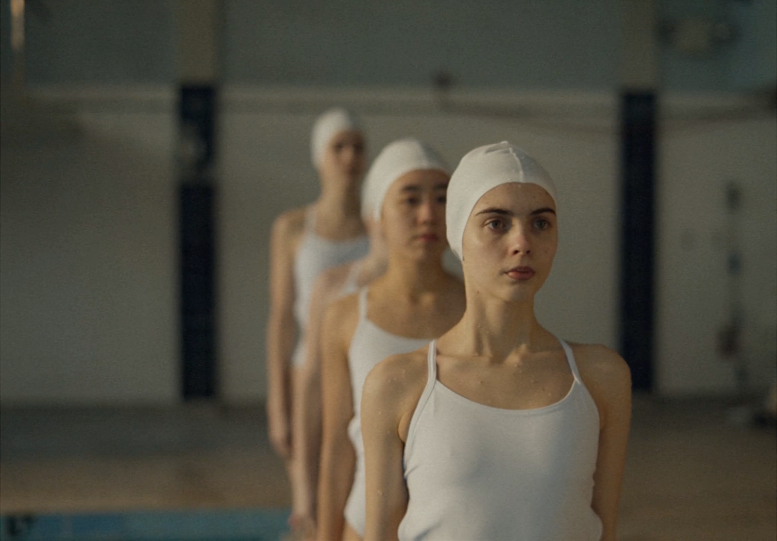 a group of women standing next to each other near a swimming pool