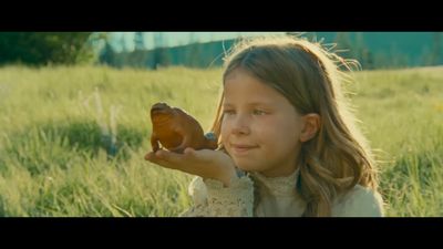 a little girl holding a toy frog in her hand