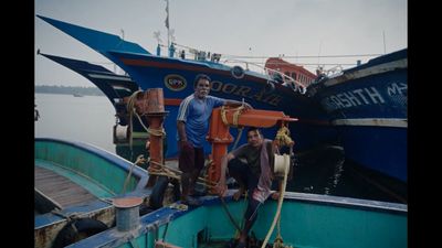 a couple of men standing on top of a boat