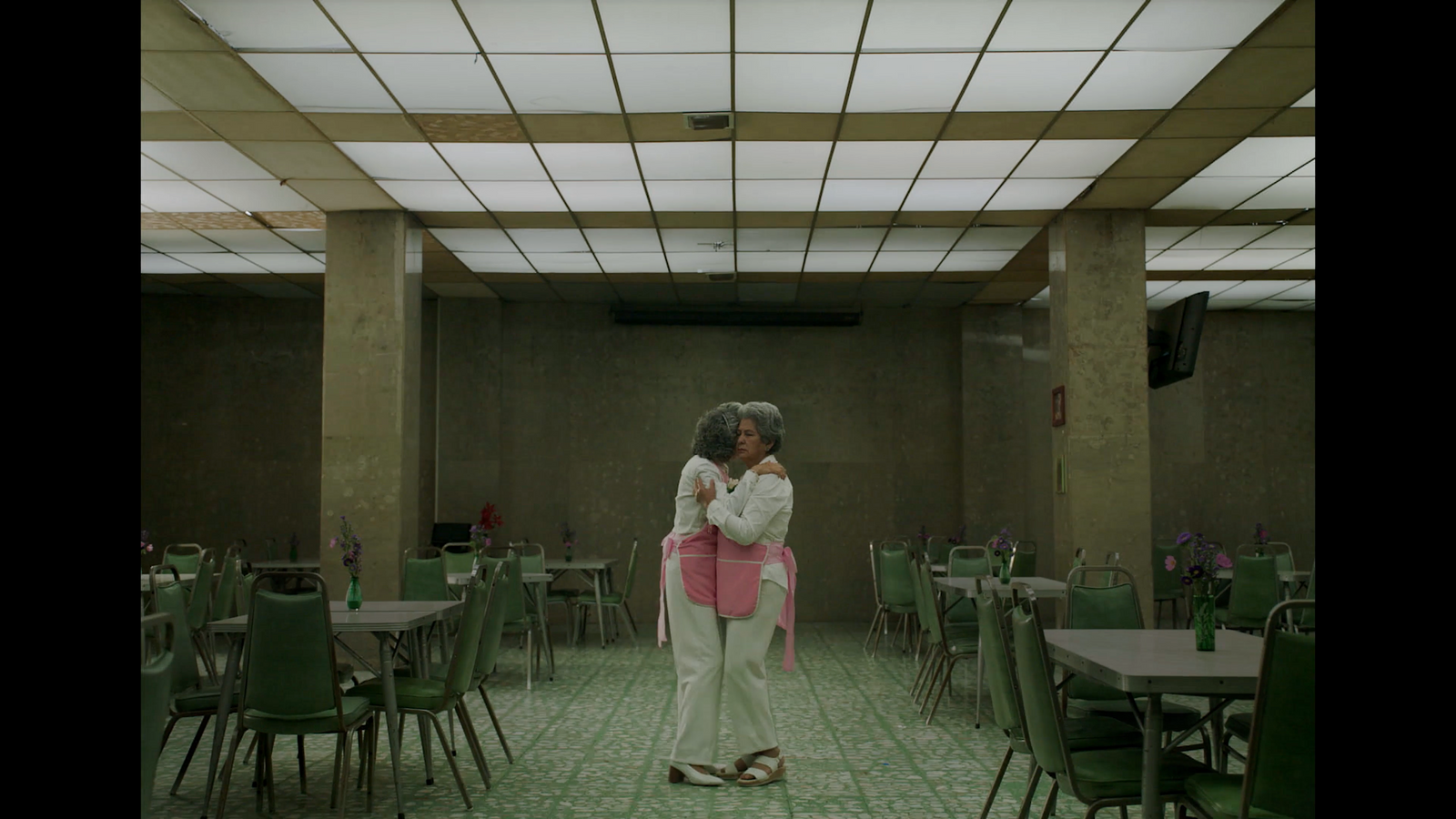 a woman standing in a room with tables and chairs