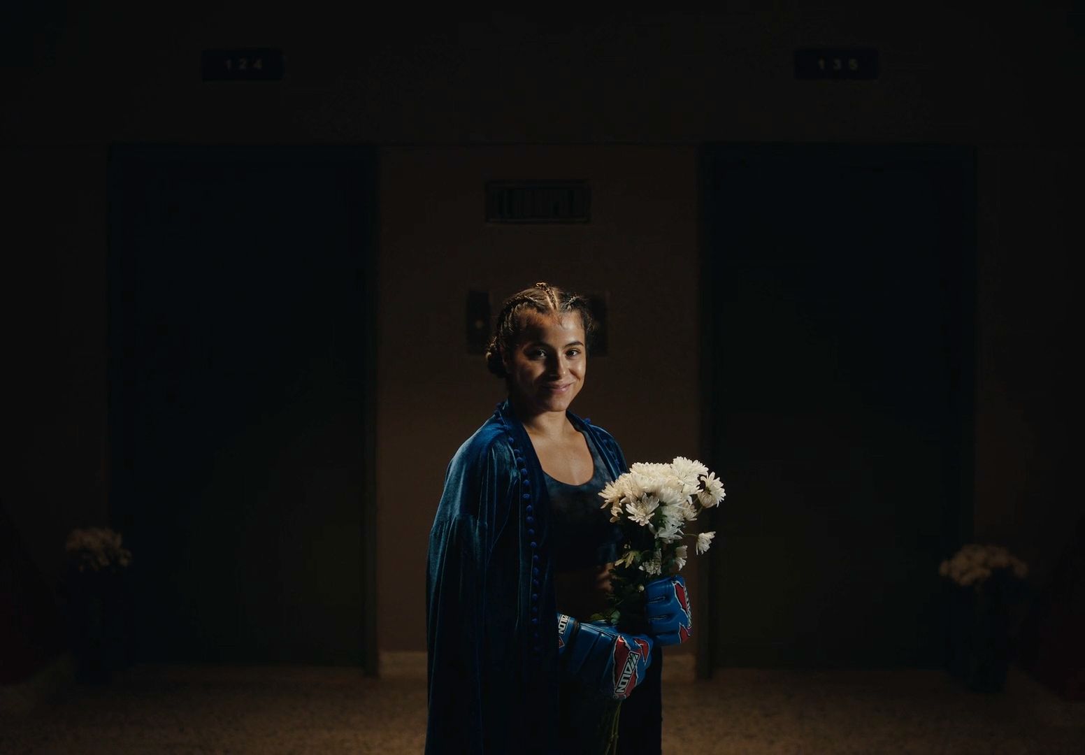 a woman in a blue dress holding a bouquet of flowers