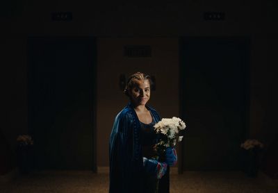 a woman in a blue dress holding a bouquet of flowers