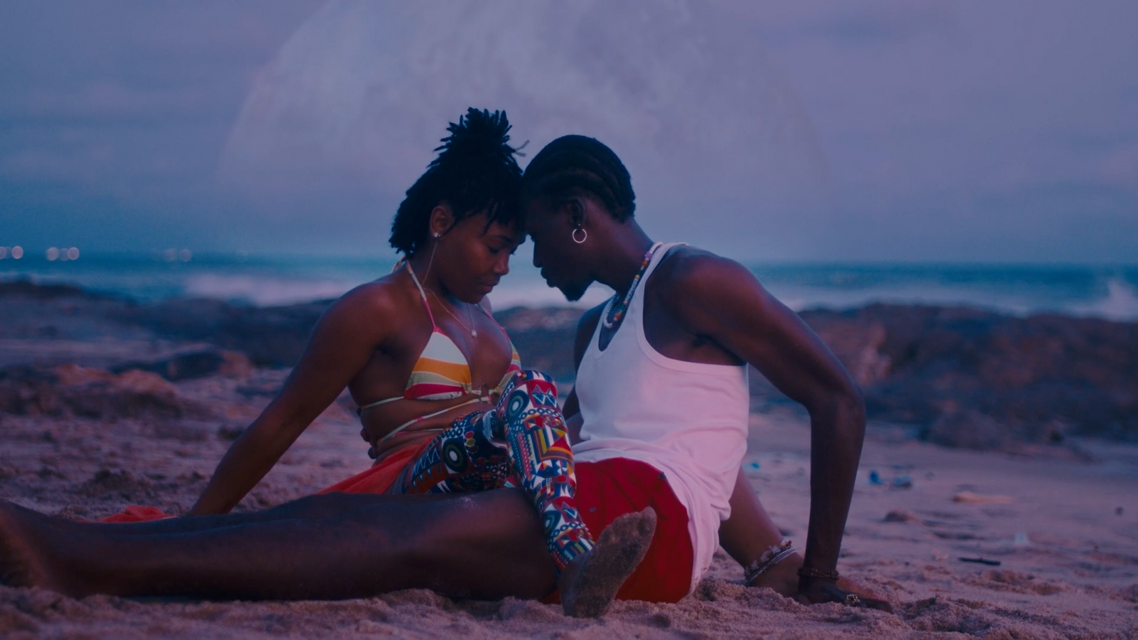 a man and a woman sitting on the beach